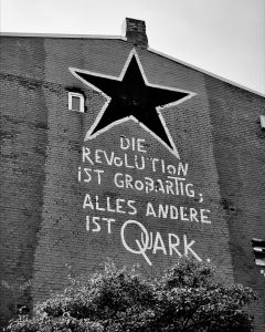 Schwarz/Weiß Foto einer Fassade in Hannover mit der Aufschrift "Die Revolution ist Großartig, alles andere ist Quark"